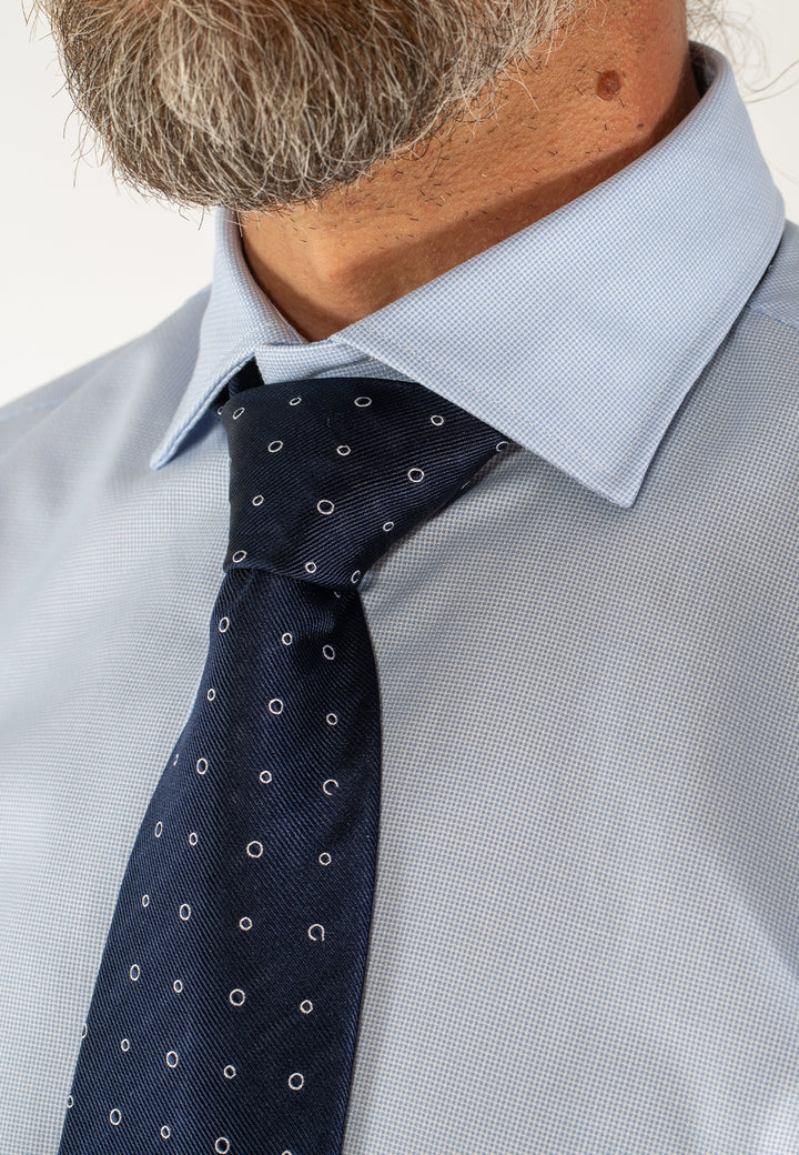 Cravatta uomo blu con fantasia ad anelli bianchi in pura seta